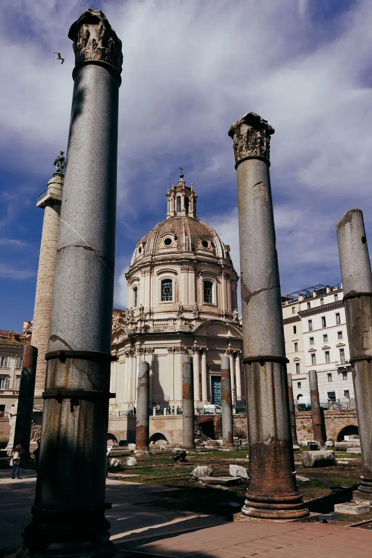 Stone columns framing a church dome in Rome.